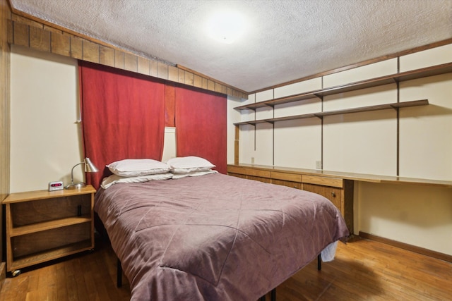 bedroom featuring hardwood / wood-style flooring and a textured ceiling