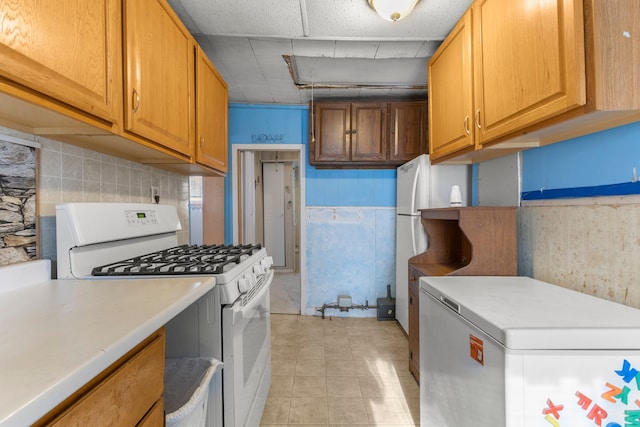 kitchen with fridge and white range with gas cooktop