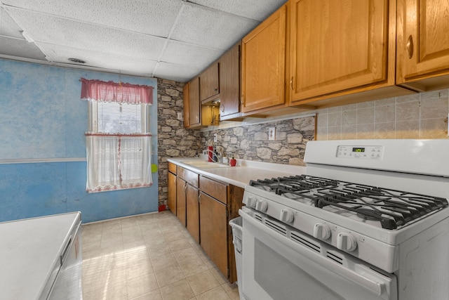 kitchen with sink, a paneled ceiling, and white range with gas cooktop