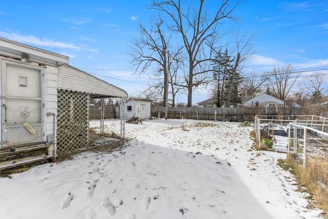 yard layered in snow featuring a storage shed