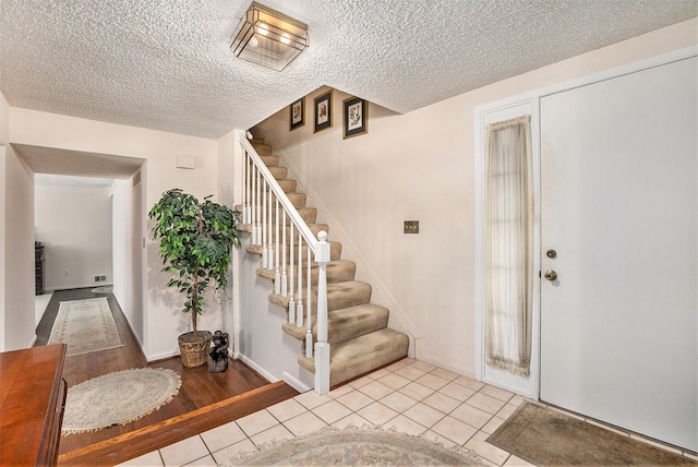 tiled foyer featuring a textured ceiling