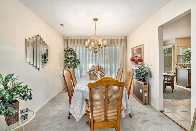 carpeted dining room featuring an inviting chandelier