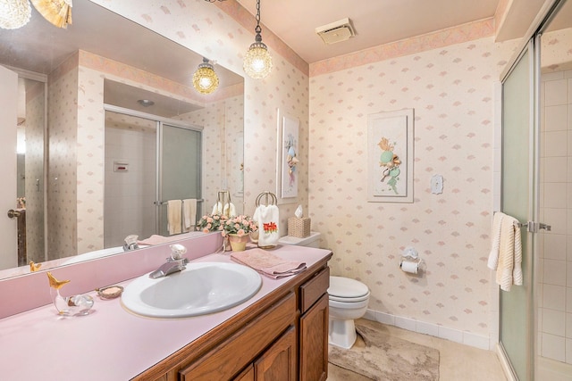 bathroom featuring an enclosed shower, vanity, tile patterned floors, and toilet