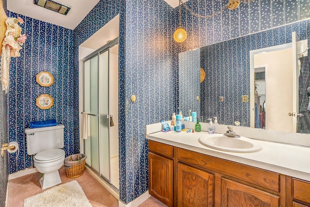 bathroom featuring vanity, toilet, and a shower with shower door