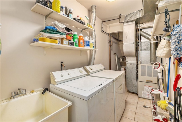 washroom with sink, light tile patterned floors, and independent washer and dryer