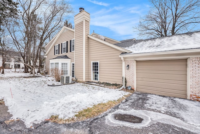 exterior space with a garage and central AC