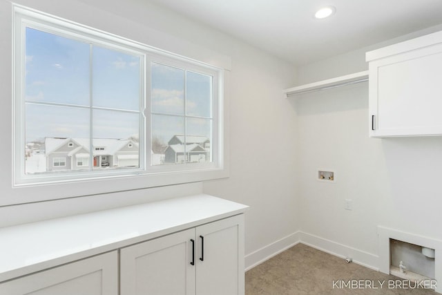 clothes washing area with cabinets and washer hookup