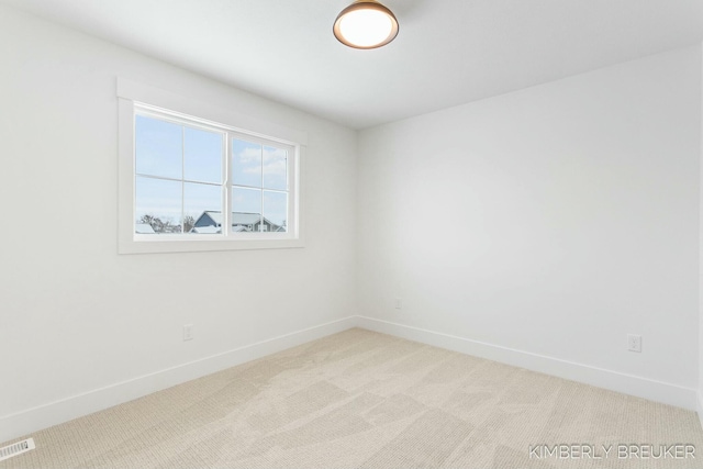 unfurnished room featuring light colored carpet