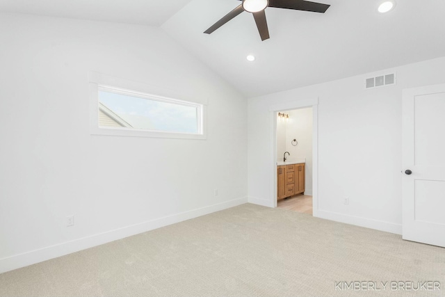 unfurnished bedroom featuring ensuite bathroom, sink, light colored carpet, ceiling fan, and lofted ceiling