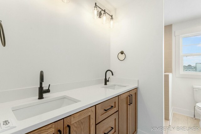 bathroom featuring toilet, tile patterned flooring, and vanity