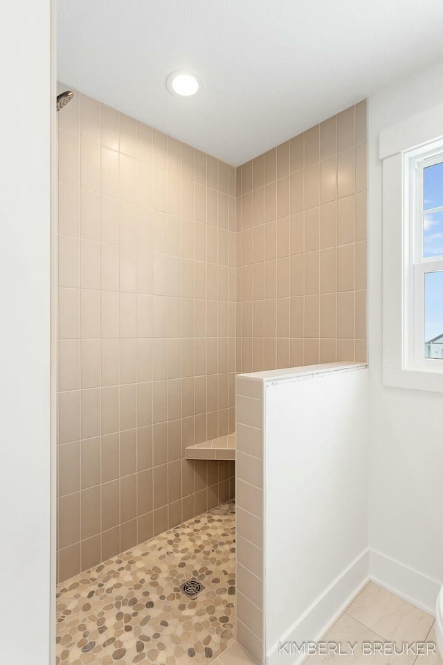 bathroom featuring tiled shower and tile patterned flooring