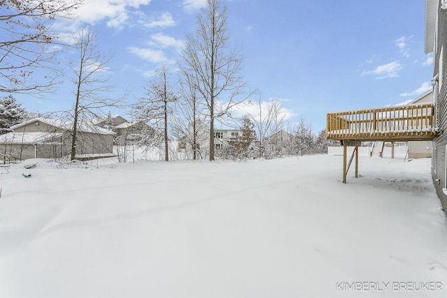 yard layered in snow with a wooden deck