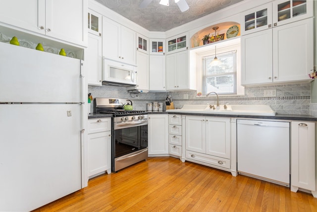 kitchen with light wood finished floors, white appliances, white cabinetry, and tasteful backsplash