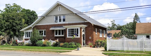 bungalow-style house featuring brick siding, a front lawn, and fence