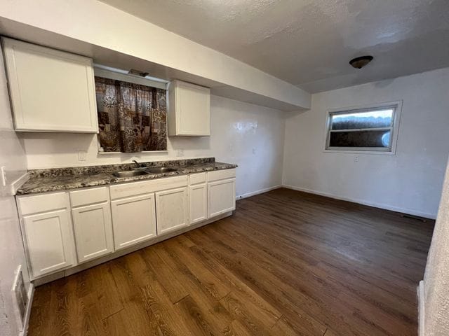 kitchen featuring white cabinets, dark hardwood / wood-style flooring, and sink