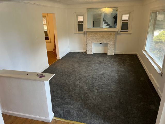 unfurnished living room with dark carpet