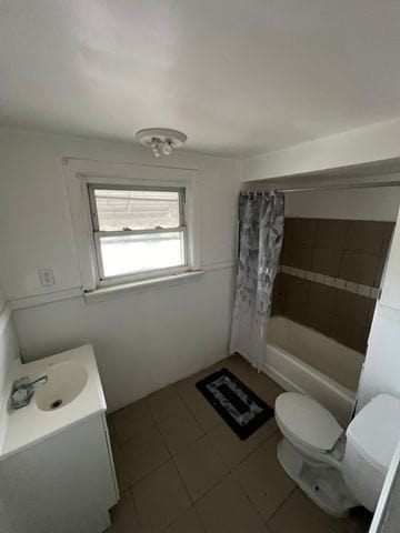 full bathroom with shower / bath combo, toilet, and vanity