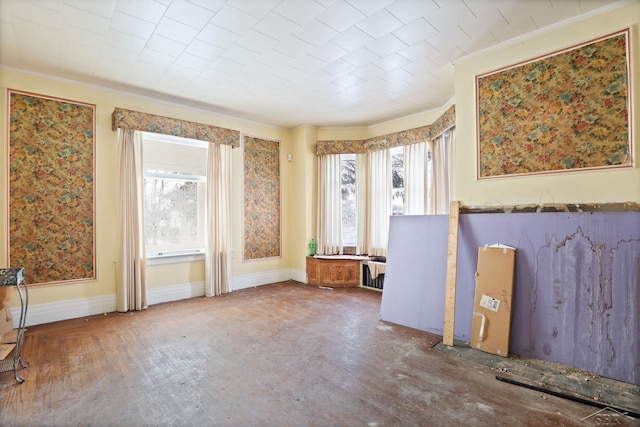 unfurnished room featuring hardwood / wood-style floors, ornamental molding, and a healthy amount of sunlight