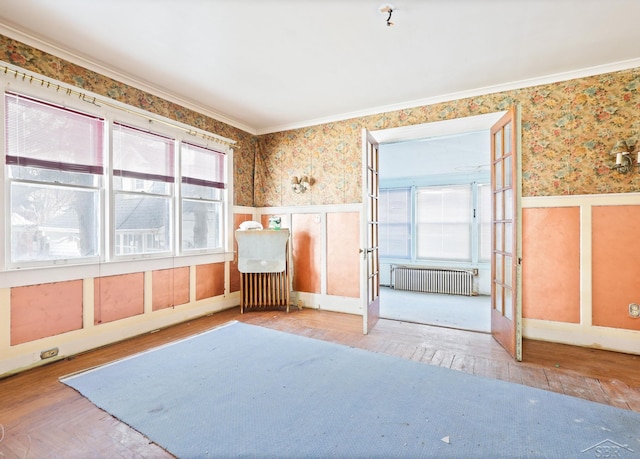 unfurnished room featuring radiator heating unit, ornamental molding, and plenty of natural light