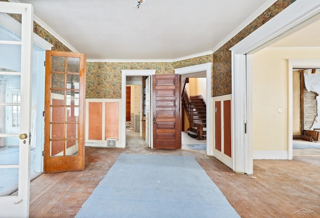 interior space featuring hardwood / wood-style flooring, ornamental molding, and french doors