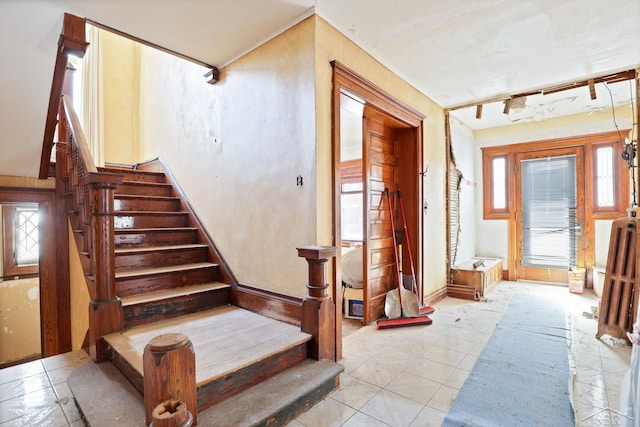 stairway with track lighting and a healthy amount of sunlight