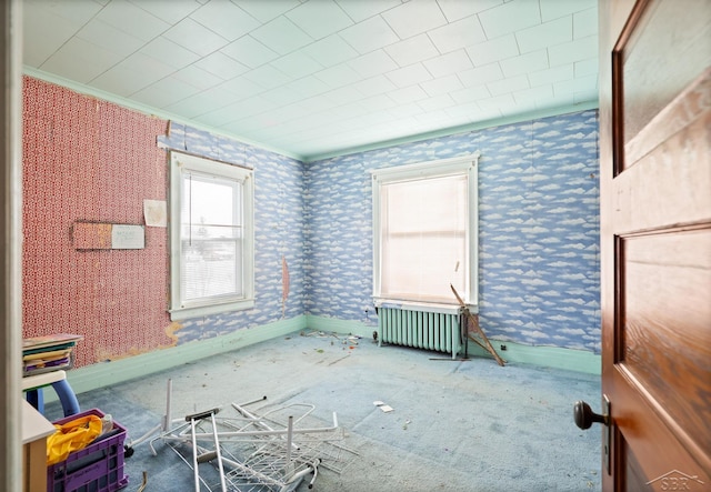 empty room featuring radiator heating unit and crown molding