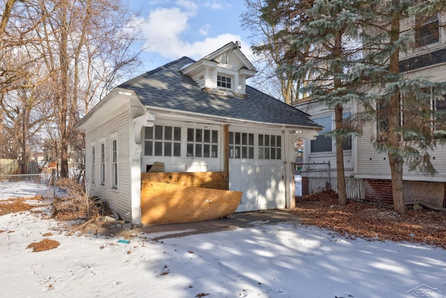 view of front of house featuring a garage and an outbuilding