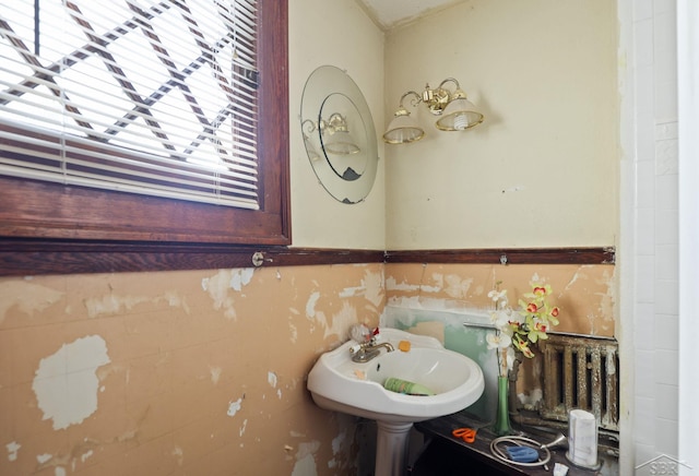 bathroom with sink, radiator heating unit, and a healthy amount of sunlight