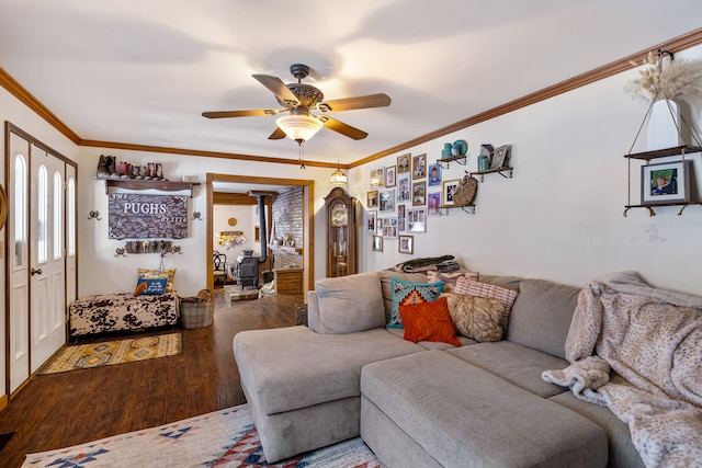 living room with crown molding, a wood stove, hardwood / wood-style floors, and ceiling fan