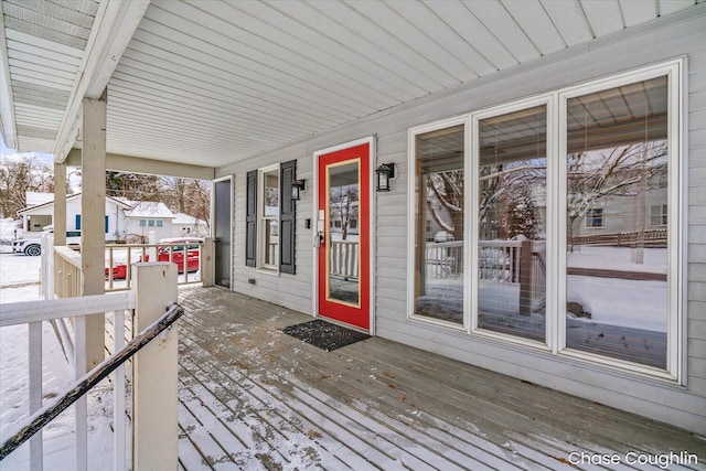 snow covered deck featuring a porch