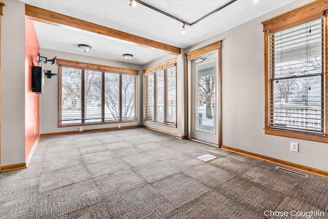 empty room with track lighting and carpet floors