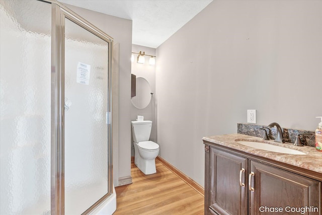 bathroom featuring hardwood / wood-style floors, toilet, a textured ceiling, walk in shower, and vanity