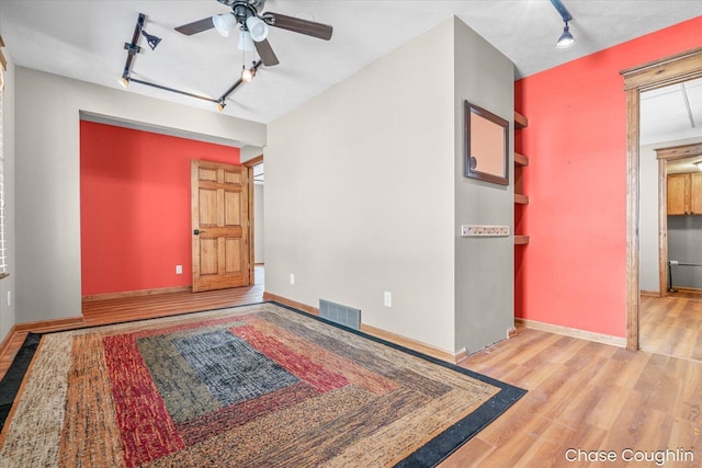 interior space featuring ceiling fan, light hardwood / wood-style flooring, and track lighting