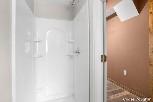 bathroom with a shower and hardwood / wood-style floors