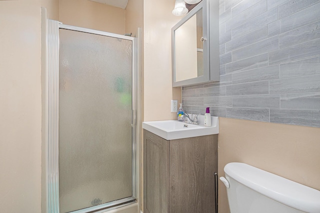 bathroom with backsplash, toilet, vanity, and an enclosed shower