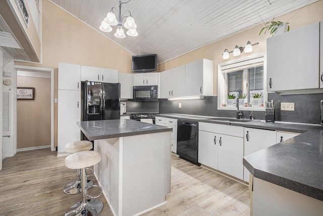 kitchen featuring sink, white cabinets, black appliances, and a center island