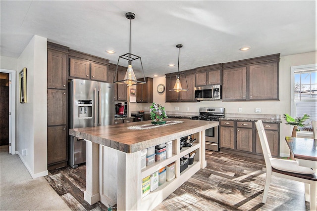 kitchen with stainless steel appliances, a kitchen island, and dark brown cabinetry