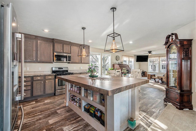 kitchen featuring a healthy amount of sunlight, a center island, pendant lighting, and appliances with stainless steel finishes