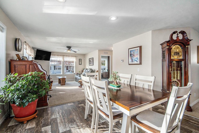 dining space featuring ceiling fan and dark wood-type flooring