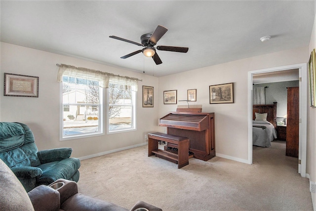 living area featuring ceiling fan and light colored carpet