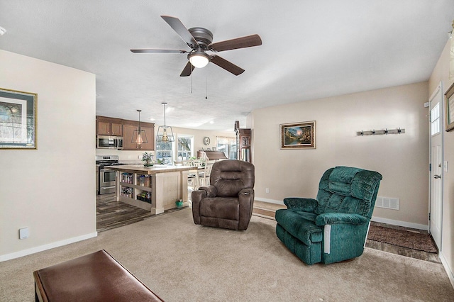 living area with light carpet and ceiling fan