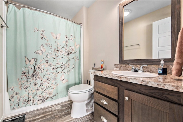 bathroom featuring hardwood / wood-style flooring, toilet, a shower with shower curtain, and vanity