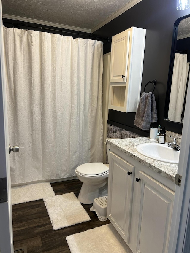 bathroom featuring toilet, crown molding, hardwood / wood-style floors, a textured ceiling, and vanity