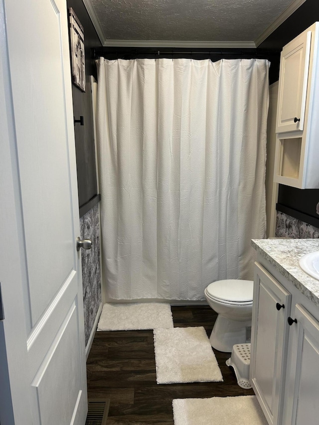 bathroom featuring vanity, ornamental molding, a textured ceiling, and hardwood / wood-style floors