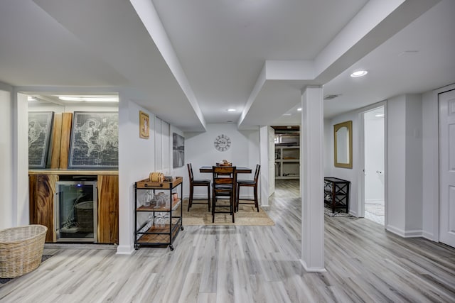 bar featuring wine cooler and light hardwood / wood-style floors