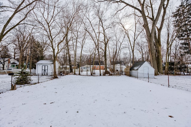 yard covered in snow featuring a shed