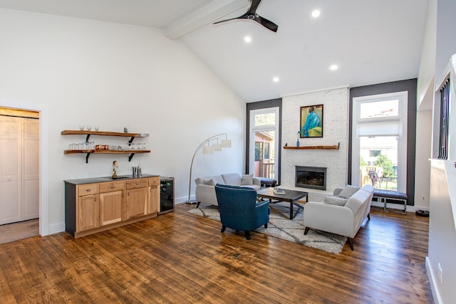 living room with dark wood-type flooring, beam ceiling, a wealth of natural light, a brick fireplace, and beverage cooler