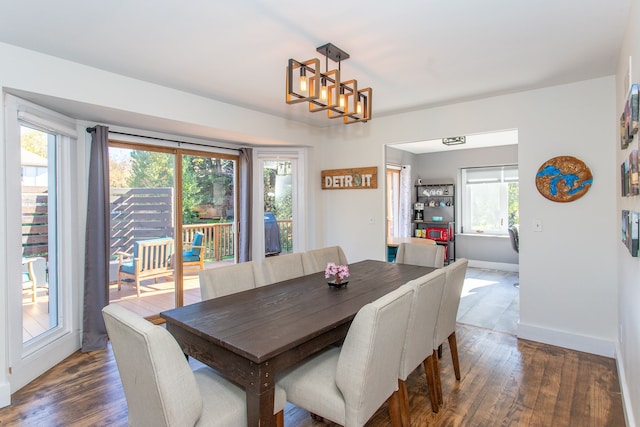 dining room with plenty of natural light, dark hardwood / wood-style floors, and an inviting chandelier