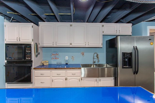 kitchen featuring sink, black appliances, and white cabinets