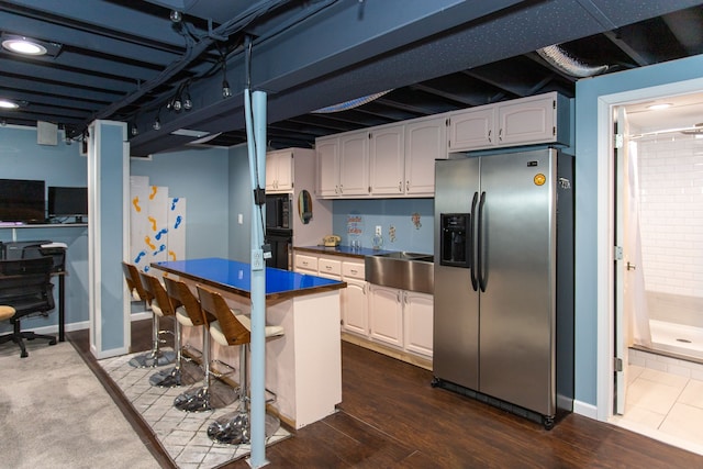 kitchen featuring black appliances, white cabinets, dark hardwood / wood-style flooring, and sink